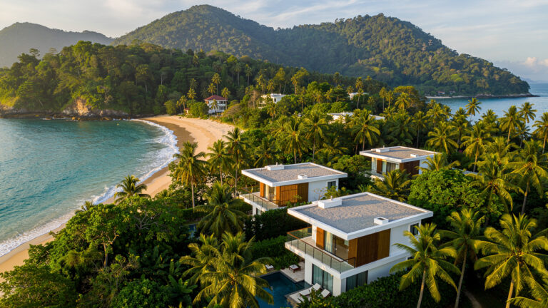 Vue aérienne réaliste de Koh Samui montrant des villas contemporaines entourées de palmiers, la mer turquoise et le relief tropical dans la lumière douce du matin.